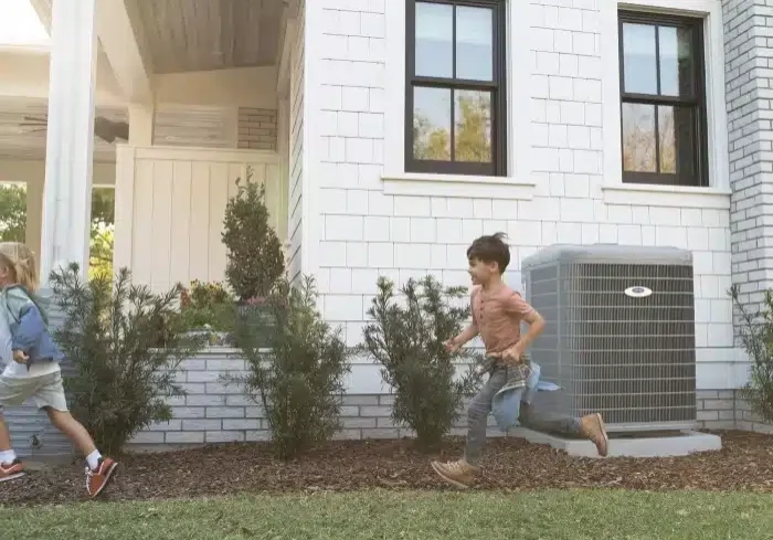 boys-running-by-carrier-heat-pump