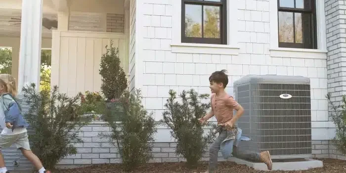 boys-running-by-carrier-heat-pump